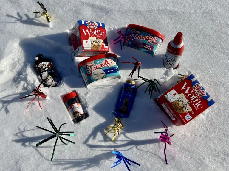 Ice cream and toppings laying on snow.